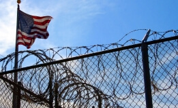 barbed wire fence and american flag