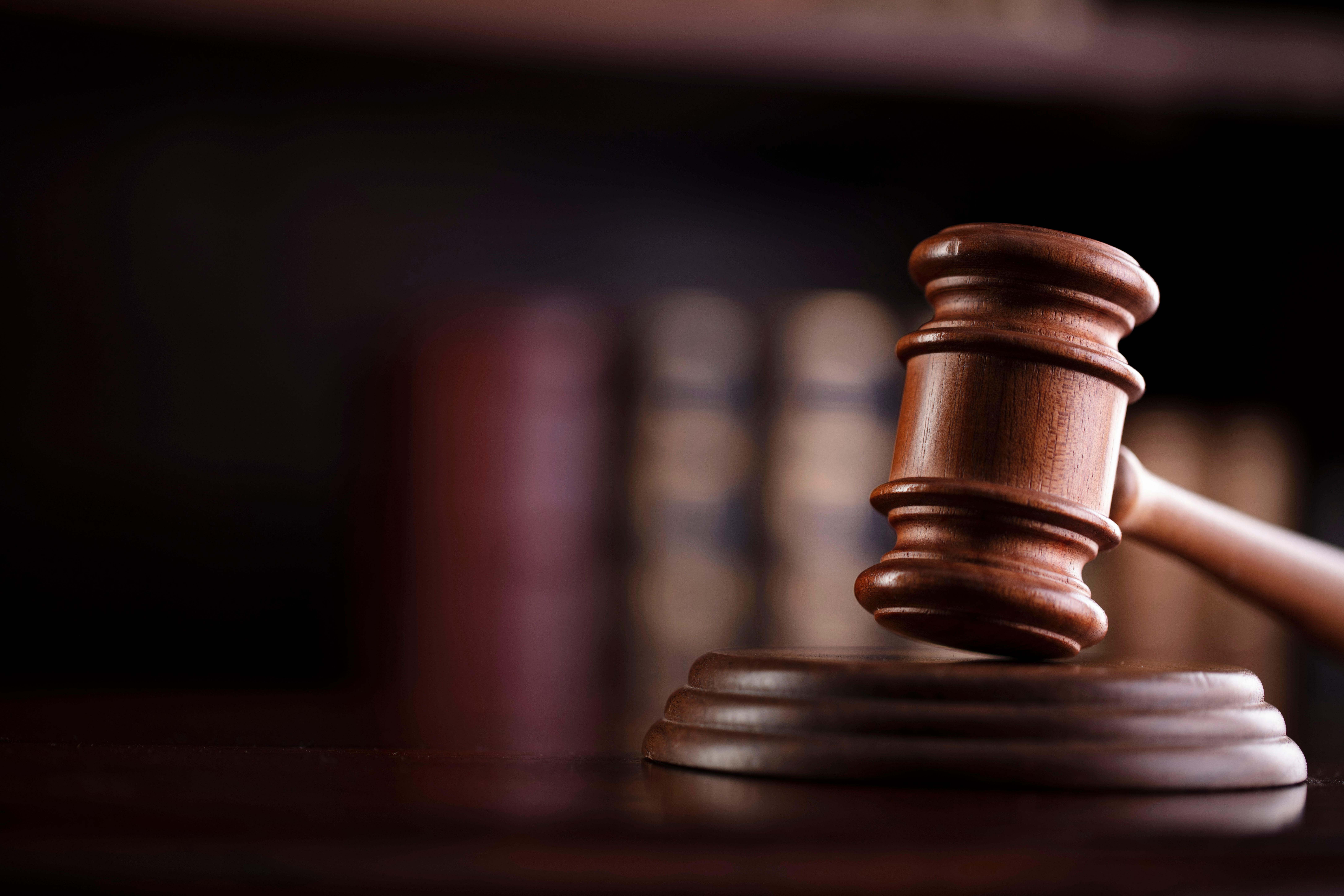 A gavel with a bookcase behind it. 