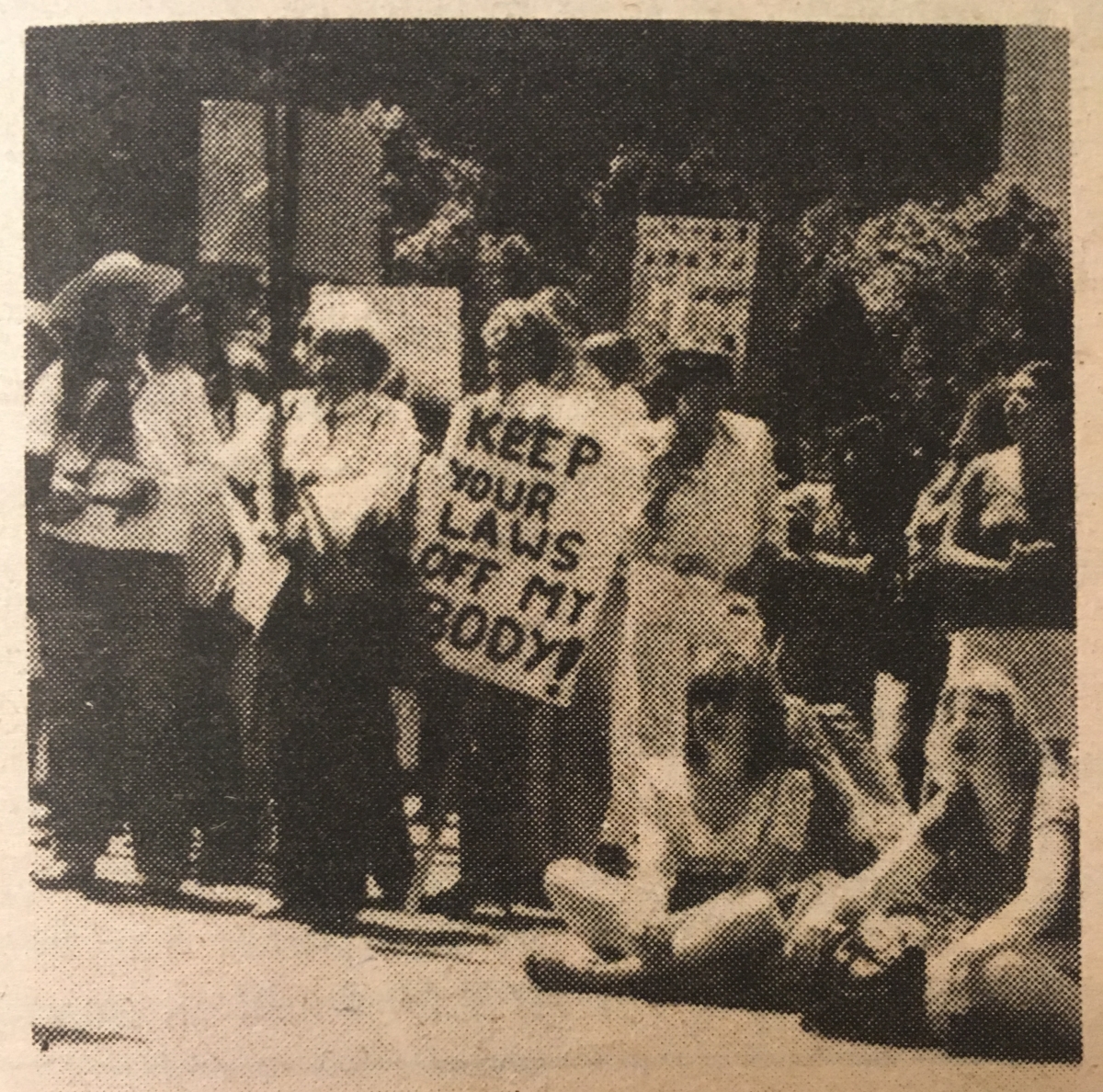 An old photo of a woman at a pro-choice rally in San Francisco holding a sign saying "keep your laws off my body!"