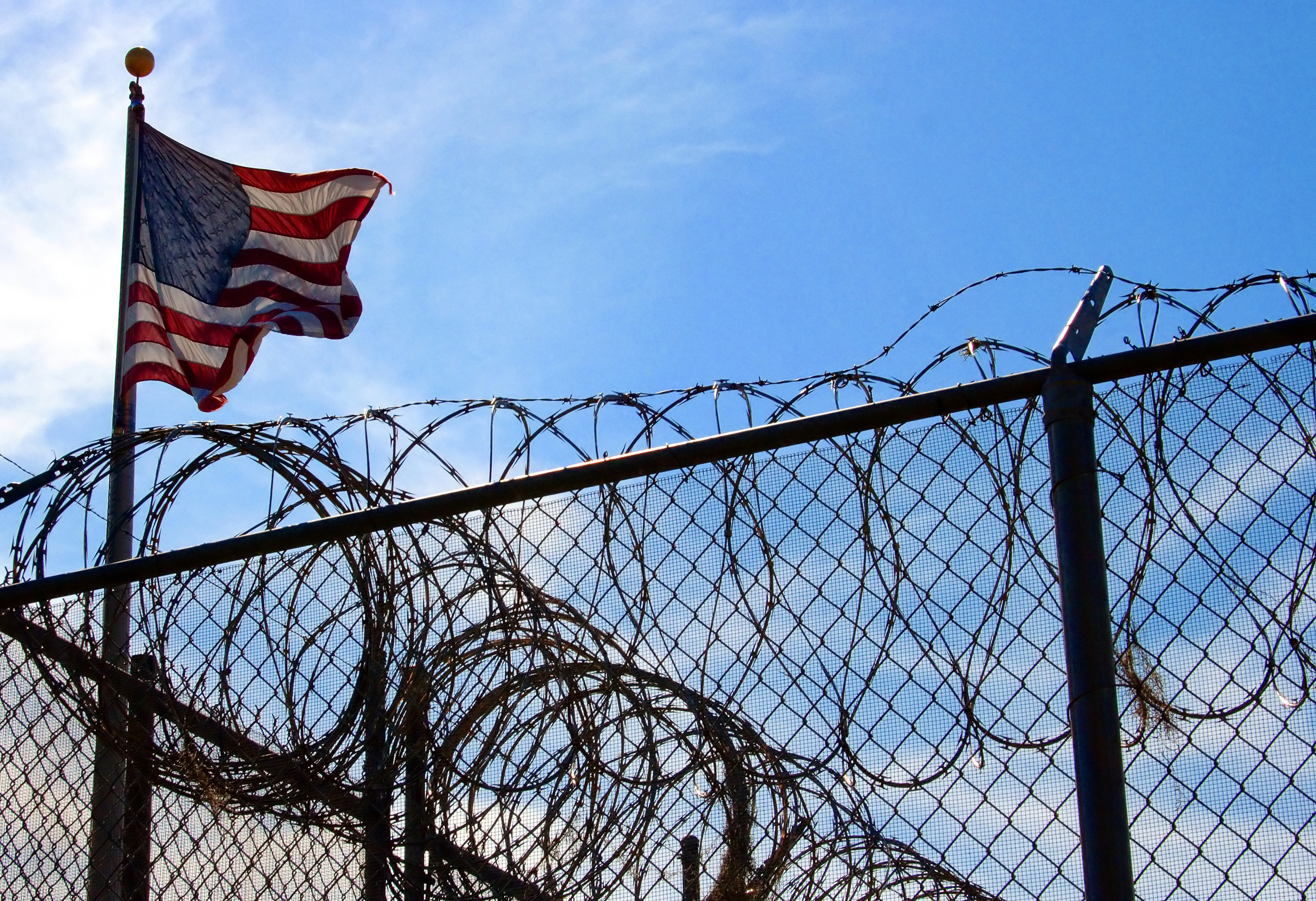 barbed wire fence and american flag