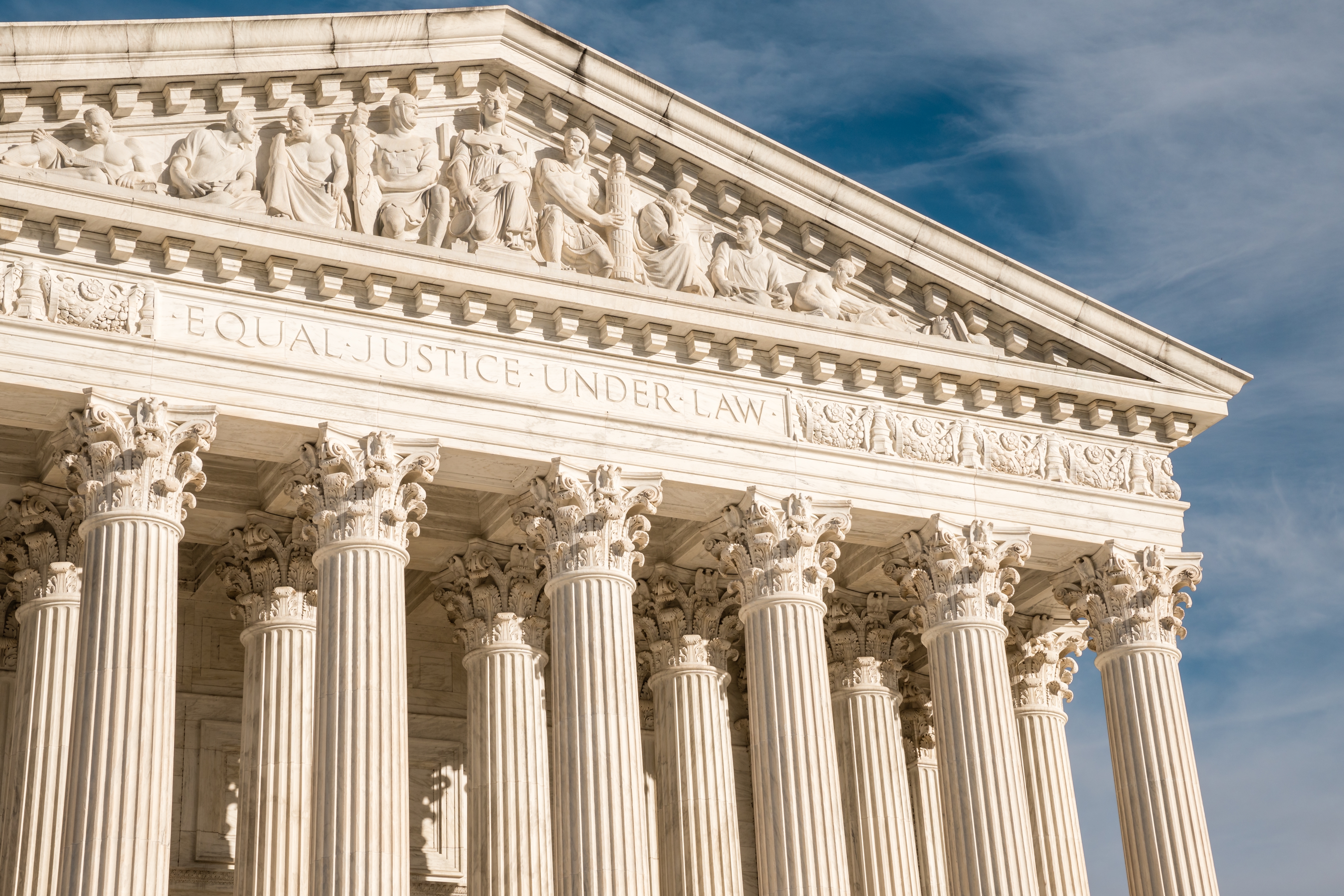 facade of the United States Suprement Court in Washington, DC with blue sky
