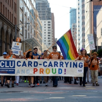 People marching with banner that reads "card carrying and proud"