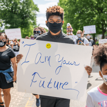 Young person holding sign during a march that reads "I am your future"