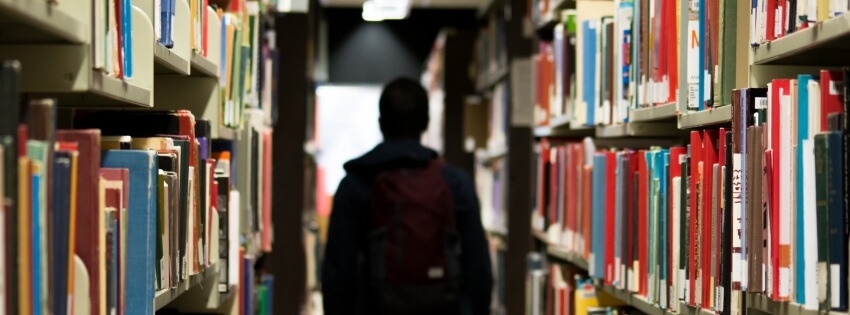 student walking down an aisle in the library