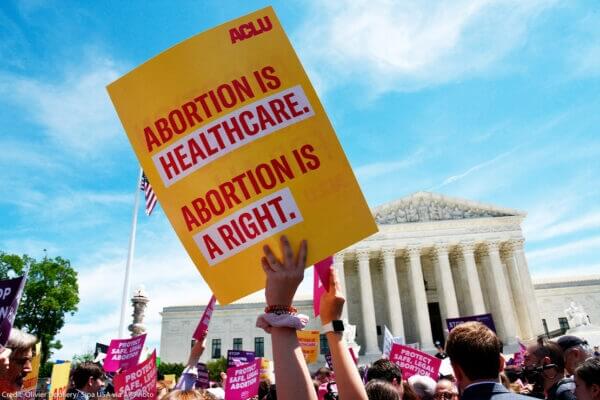 Poster being held up that reads Abortion is healthcare, Abortion is a right