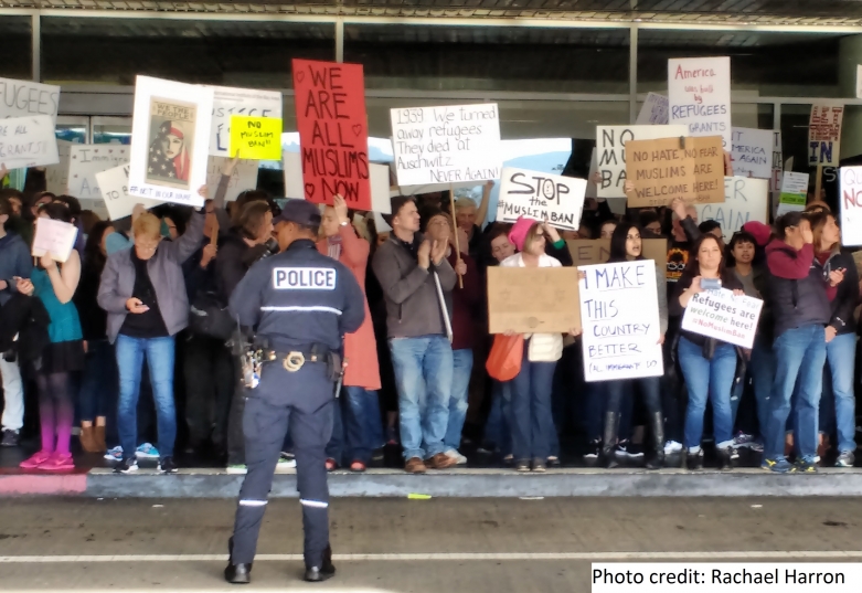 Protesters at SFO hold signs speaking out against the Muslim ban