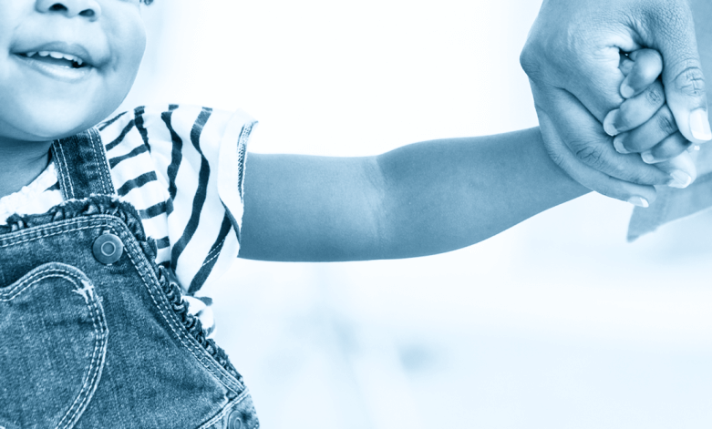 A photo of a young child holding her mother's hand.