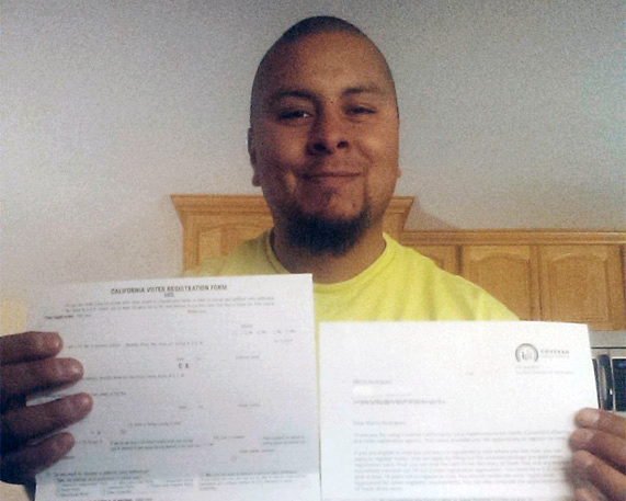 Marco Rodriguez receives his voter registration card from Covered California. 