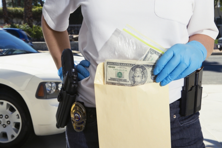 police officer with cash / shutterstock