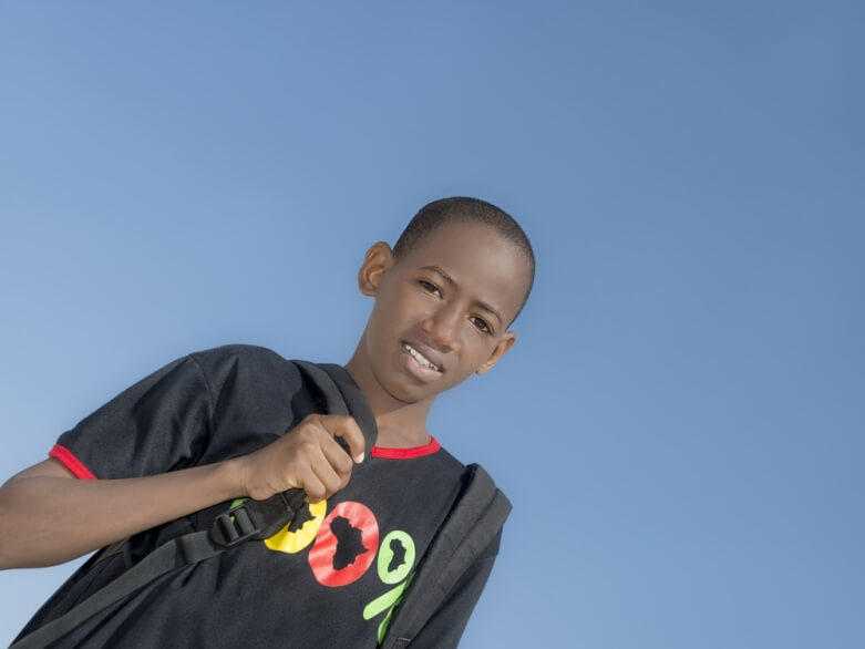 stock photo of a school aged youth of color wearing a backpack