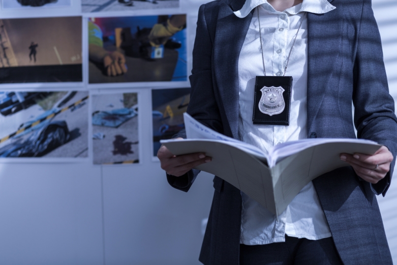 cop holding a file folder - shutterstock