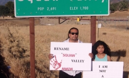 Indigenous Justice advocate Roman Rain Tree pictured with his daughter in front of a sign reading "Squaw Valley"