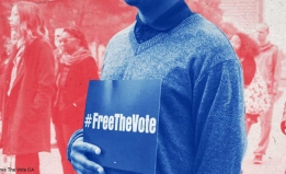person holding a #freethevote sign in front of a crowd of people