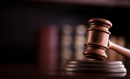 A gavel with a bookcase behind it. 