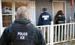 ICE agents standing in front of a home, knocking on the door. 