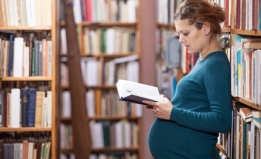 Pregnant woman reads in a library