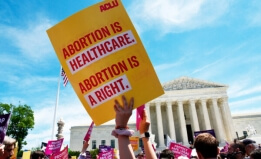 Poster being held up that reads Abortion is healthcare, Abortion is a right
