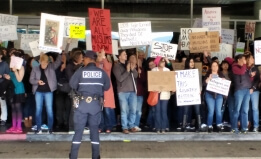 Protesters at SFO hold signs speaking out against the Muslim ban