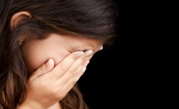 a child holds her face in her hands