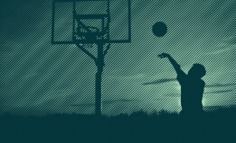 A teenage boy plays basketball
