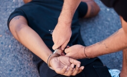 Person on the ground being handcuffed