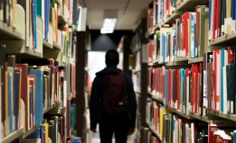 student walking down an aisle in the library