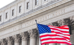 U.S. flag waving in the wind in front of United States Court House