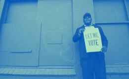 Man holding sign saying "let me vote"