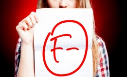 young person holding a graded paper with an 'F'