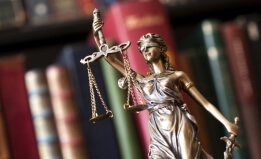 Justice statue in front of law books.