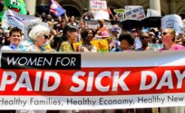 people protesting with a banner calling for paid sick days