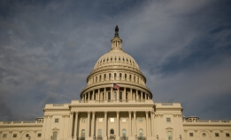 A photograph of the U.S. Capitol with stormy clouds in the background