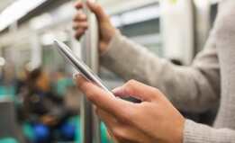 person on a cell phone on the subway