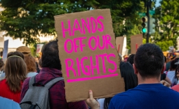 Protestor holds sign reading "Hands off our Rights"