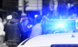 Police vehicle with a crowd in the background