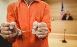Prisoner in handcuffs clenching fists in the court room