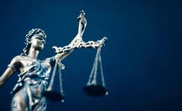 Lady justice holding scale against blue background. 