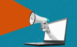 Hand holding a megaphone from laptop monitor