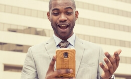 man looking into his smart phone - shutterstock