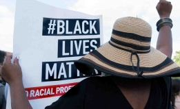 Woman holding black lives matter sign.
