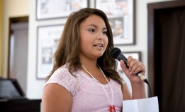 Zoey, a transgender girl speaking into a microphone.