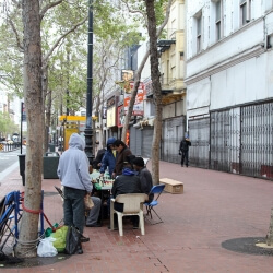 People play chess in the early evening along Market St in the Tenderloin neighbourhood, near the intersection with Turk and Mason Streets. San Francisco, California, USA.